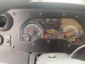 The dashboard of a 2012 Ford Econoline showing speedometer tachometer fuel gauge and various warning lights with the gear shift in the park position