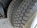 Close-up of a large truck tire with deep treads showcasing its rugged design and textured surface ideal for heavy-duty performance