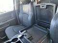 Interior of a 2011 RAM 1500 showing black leather seats and an open center console with a storage compartment