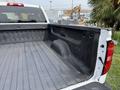 White 2018 Chevrolet Silverado 1500 truck bed with a textured black liner and side walls showing a smooth surface and tire well