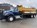 A 2016 International 7400 truck with a blue cab and a yellow dump bed attached to the back