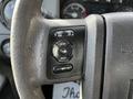 A close-up of the steering wheel controls of a 2011 Ford F-450 SD featuring buttons for cruise control setup and information settings