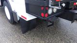 The rear section of a 2005 International 4300 truck showing taillights mud flaps and a towing hitch