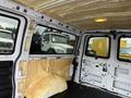 Interior of a 2012 Chevrolet Express van with insulation material on the walls and a bare floor