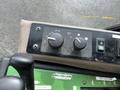 A control panel from a 2014 John Deere 1585 Terrain Cut featuring two large knobs and several switches for operation functions