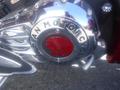 Close-up of a chrome engine cover featuring the Indian Motorcycle logo and a red emblem of a Native American chief