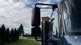 A blue 2009 International 4300 truck showing the side mirror and cab details