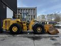 A 2006 John Deere 470G wheel loader in yellow with large tires and a front bucket attachment
