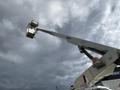 A white 2008 Ford Econoline with a raised aerial work platform attached at the top, positioned against a cloudy sky