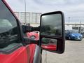 A close-up view of the side mirror of a red 2013 Ford F-550 showcasing its rectangular shape and dual mirror design