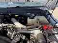 Close-up of the engine compartment of a 2014 Ford F-250 SD showing various components including hoses a coolant reservoir and battery connections