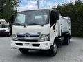 A white 2014 Hino 195 truck with a silver grille and a side-mounted waste collection container