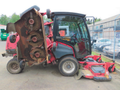 A 2013 Toro Grounds Master 5910 with a raised mower deck showing multiple large blades and a red and black color scheme