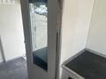 A 2004 Ford Econoline van parked in a lot seen through a doorway with a glass panel beside a metal counter