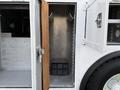 A 2005 Freightliner M2 106 vehicle with an open compartment showing metal wall and a black storage box on the floor
