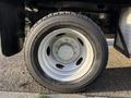 A close-up of a wheel and tire from a 2006 Ford F-550 featuring a silver wheel rim with multiple bolt holes and a black tire with visible tread patterns