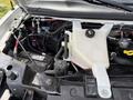 Engine compartment of a 2017 Chevrolet Express showing various components including hoses wires and a coolant reservoir