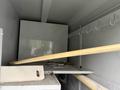 A 2014 International TerraStar with an empty cargo area containing shelves and hooks along the walls