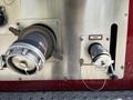 A close-up of a 2006 Emergency One Fire Truck featuring metal intake and discharge valves with labeled knobs and handles