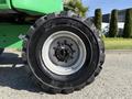 A large tire from a 2015 JLG 450AJ with a rugged tread pattern and metallic wheel rim