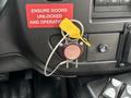 A key with a yellow tag is inserted into a round red button labeled FIRE attached to the dashboard of a 2020 Chevrolet Express