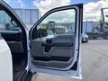 2016 Ford F-150 with the driver's side door open showcasing the interior door panel and controls