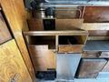 A wooden storage unit with multiple compartments including cabinets and shelves inside a 2008 Morgan Olson Workhorse vehicle