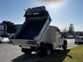 A 2008 Ford F-450 SD dump truck with its bed elevated for unloading materials