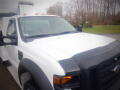 2008 Ford F-550 with a white body and black detailing featuring multiple orange roof lights and a front grille with a distinctive design