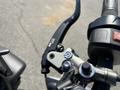 Close-up of the handlebar controls of a 2018 Triumph Street Triple RS featuring a black brake lever and silver throttle assembly