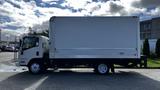 A 2016 Isuzu NPR box truck with a white cargo area and a dark chassis parked on a street