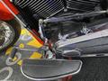 Close-up of a 2024 Harley Davidson Fat Boy motorcycle showcasing the chrome engine components and foot peg with the Harley Davidson logo