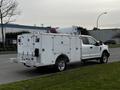 A white 2019 Ford F-350 Super Duty with a custom utility body and equipment mounted on the bed