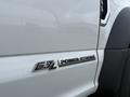 A close-up of a white 2021 Ford F600 showing the 6.7L Power Stroke turbo diesel badge on the side of the vehicle