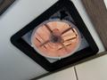 A round roof vent fan with a copper-colored grille inside a white frame