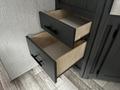 Two partially open drawers with black handles and light wood interiors, part of a 2022 Aspen Trail cabinet system