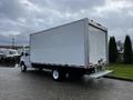 A white 2019 Ford Econoline box truck with a sleek design and rear loading door parked in an outdoor setting