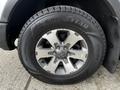 A close-up view of a silver alloy wheel with a Goodyear tire featuring deep treads mounted on a 2014 Ford F-150