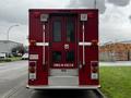 A red 1995 Freightliner FL70 fire rescue vehicle with multiple lights and doors at the rear featuring the words FIRE RESCUE