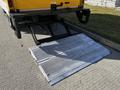 A 2017 Hino 155 loading ramp is lowered to the ground with a metal surface and a textured design for traction