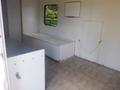 Interior of a 2004 Royal 18 Foot Office Trailer featuring a countertop with a built-in storage compartment and a large window letting in natural light