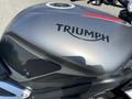 Close-up of a 2018 Triumph Street Triple RS motorcycle tank featuring the Triumph logo in bold black lettering and a textured side panel