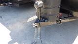 Close-up of a 2022 Aspen Trail trailer hitch with a metal coupling mechanism and security chain attached