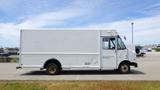 A white 2011 Ford Econoline van with a blank side panel and no visible markings parked in a lot