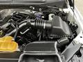 A 2016 Ford F-150 engine bay featuring the air intake system and various engine components including the black plastic air filter housing and yellow coolant reservoir
