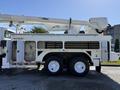 A 2008 International 7500 truck with a boom lift attachment on top and a storage compartment on the side