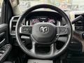 The steering wheel of a 2024 RAM 5500 with controls for audio and cruise settings visible along with the dashboard display behind it