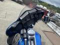 A close-up view of the handlebars and dashboard of a 2017 Harley-Davidson FLHTKL motorcycle featuring round gauges and black speakers on either side