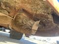 Underside view of a rusted 2010 Kubota F3990 mower deck covered in debris and grass clippings with visible metal components and washers