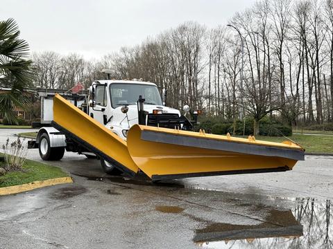 A 2016 Freightliner 108SD snow plow truck with a large yellow plow attached at the front ready for winter operations